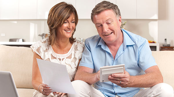 A man and woman looking at a calculator